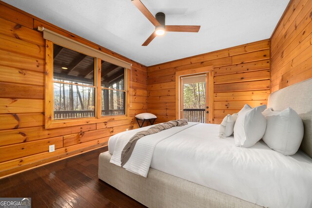 bedroom with ceiling fan, dark hardwood / wood-style floors, a closet, and wood walls