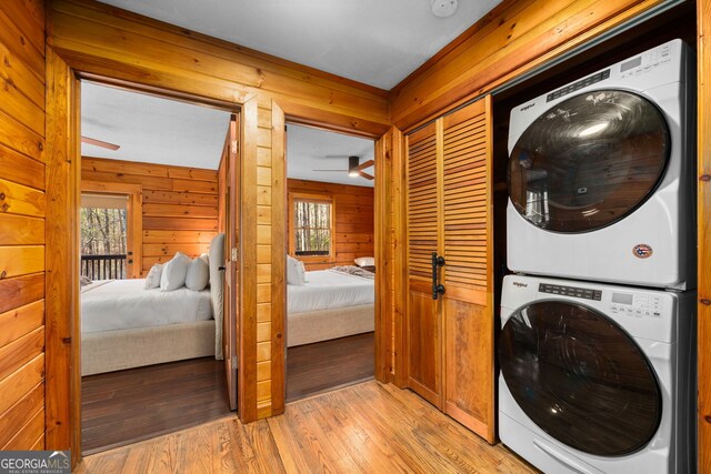 bedroom featuring access to exterior, wood walls, and multiple windows