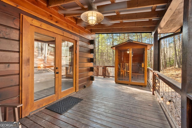 wooden terrace with french doors and a ceiling fan