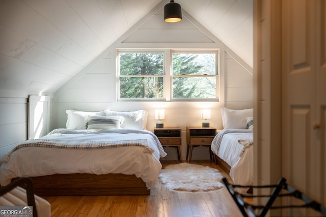 bedroom featuring lofted ceiling and light wood-type flooring