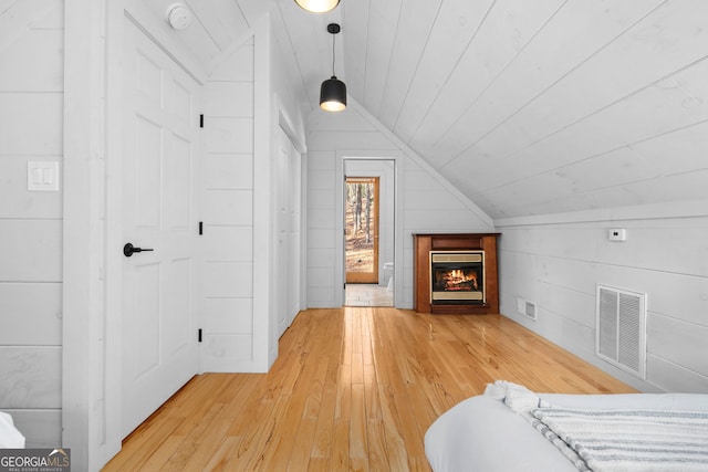 unfurnished bedroom with lofted ceiling, light wood-style flooring, wood ceiling, and visible vents