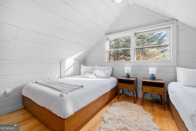 bedroom featuring lofted ceiling and light wood-style flooring