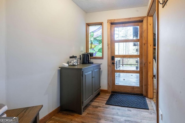 entryway featuring dark wood-type flooring and a textured ceiling