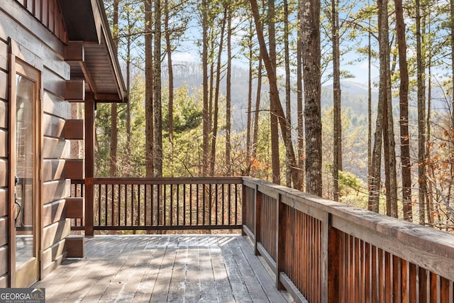 wooden deck featuring a mountain view and a view of trees