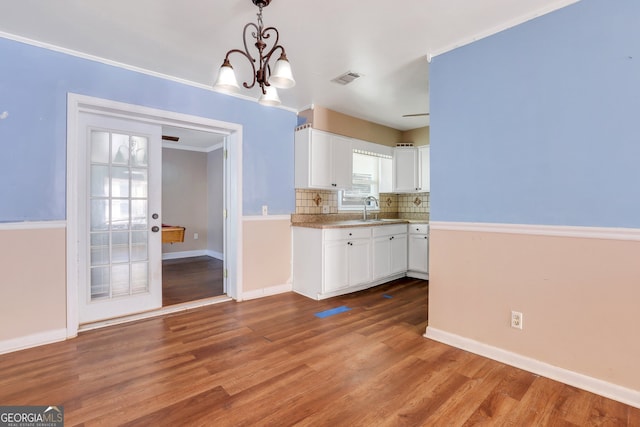 kitchen featuring a chandelier, white cabinetry, hanging light fixtures, and hardwood / wood-style floors