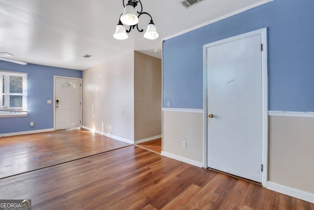 foyer entrance with hardwood / wood-style floors and a notable chandelier