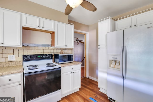 kitchen featuring white cabinetry, light hardwood / wood-style flooring, tasteful backsplash, and white appliances