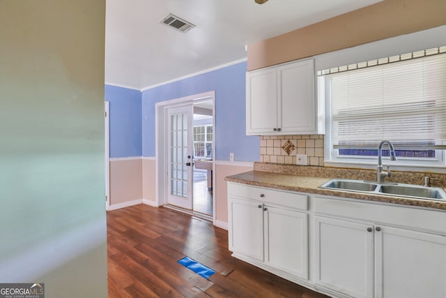 kitchen with dark hardwood / wood-style flooring, sink, tasteful backsplash, crown molding, and white cabinetry