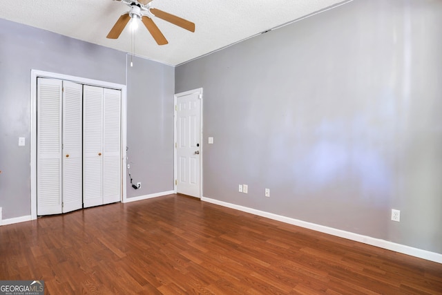 unfurnished bedroom featuring a textured ceiling, dark hardwood / wood-style flooring, ceiling fan, and a closet