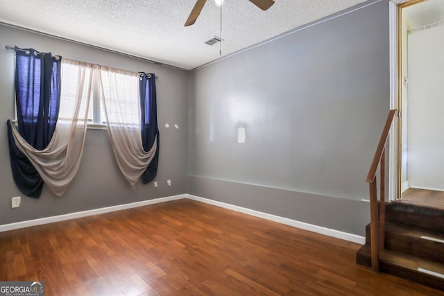 empty room featuring wood-type flooring, ceiling fan, and a textured ceiling