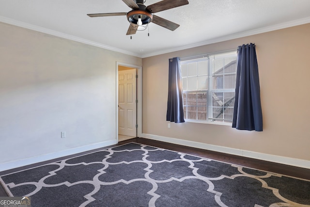 empty room featuring dark hardwood / wood-style flooring, ceiling fan, and crown molding