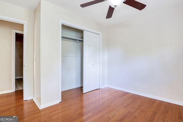 unfurnished bedroom with hardwood / wood-style flooring, ceiling fan, and a closet