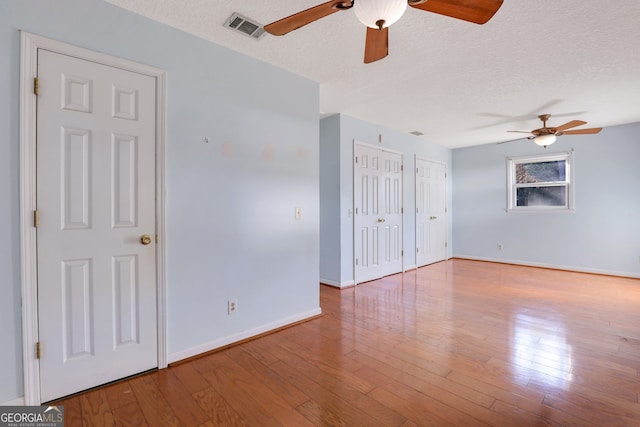 unfurnished room featuring light hardwood / wood-style flooring, a textured ceiling, and ceiling fan