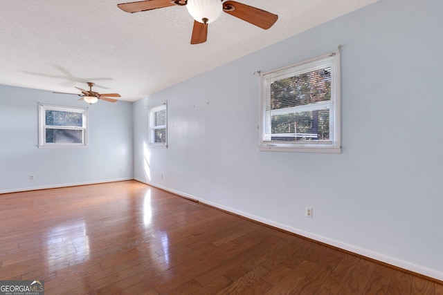 spare room with plenty of natural light, wood-type flooring, and a textured ceiling