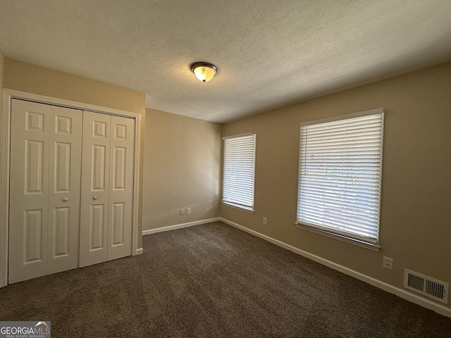 3617 Collins Dr, Douglasville, GA 30135 - unfurnished bedroom featuring baseboards, a closet, dark carpet, and a textured ceiling