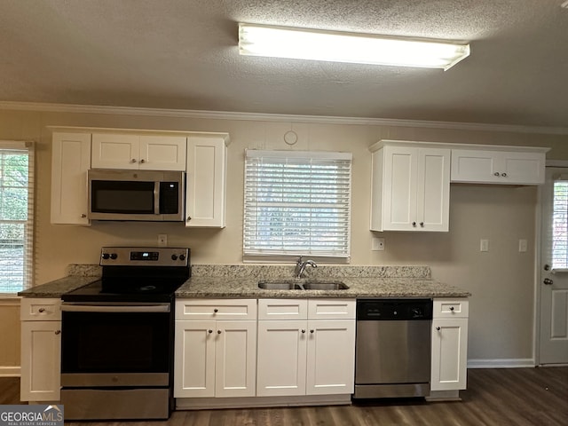 kitchen with crown molding, appliances with stainless steel finishes, dark hardwood / wood-style flooring, sink, and white cabinets