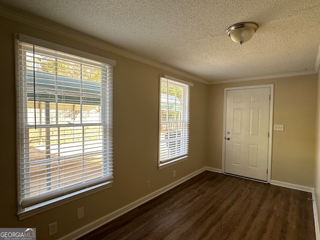 unfurnished room with dark wood-type flooring, a textured ceiling, and ornamental molding