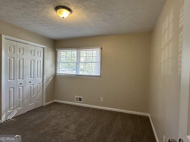 3617 Collins Dr, Douglasville, GA 30135 - unfurnished bedroom with dark colored carpet, baseboards, a textured ceiling, and a closet