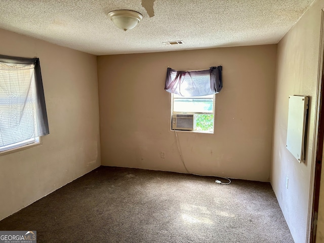 carpeted empty room featuring a textured ceiling