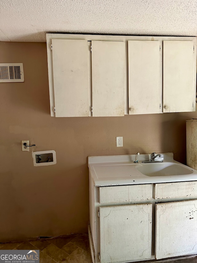 washroom featuring cabinets, washer hookup, and sink