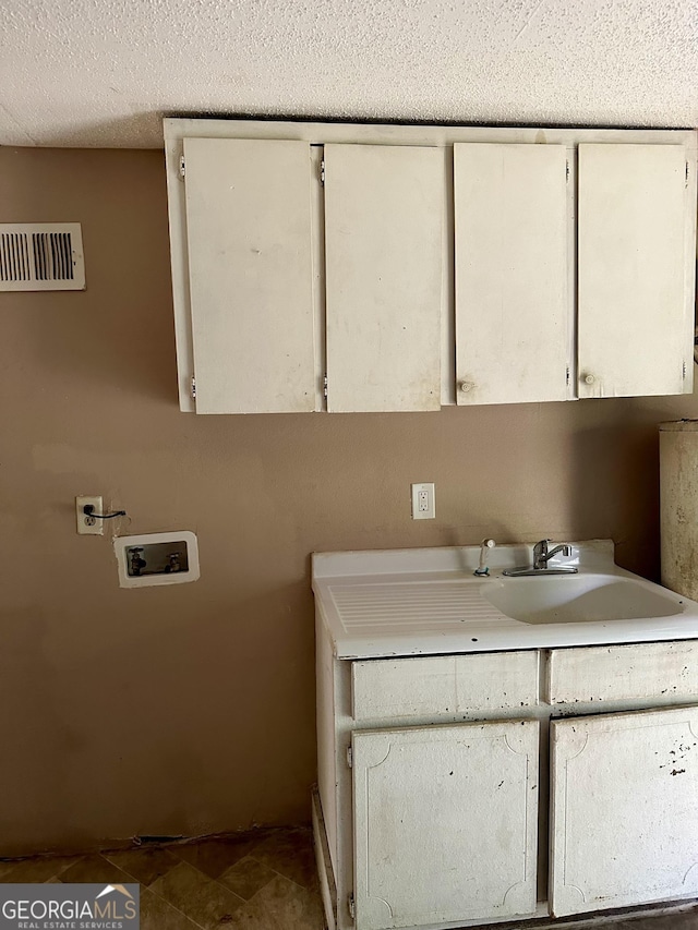 2155 Ferguson St, Macon, GA 31204 - laundry area featuring cabinet space, washer hookup, and a textured ceiling