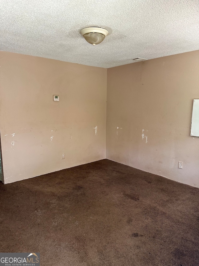 carpeted spare room with a textured ceiling