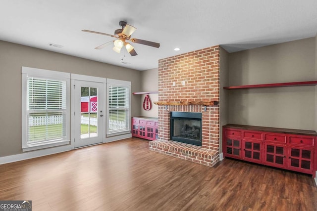 unfurnished living room featuring ceiling fan, dark hardwood / wood-style floors, and a fireplace