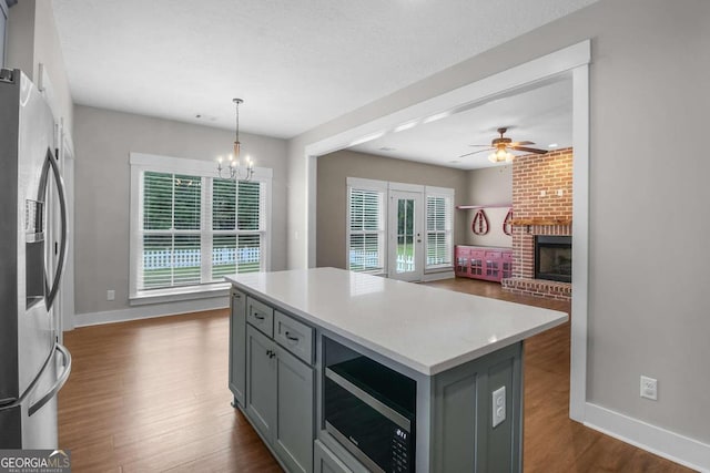 kitchen with a kitchen island, decorative light fixtures, a wealth of natural light, and appliances with stainless steel finishes