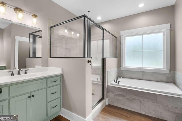 bathroom with vanity, shower with separate bathtub, and wood-type flooring