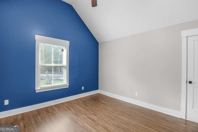 spare room featuring hardwood / wood-style floors, ceiling fan, and vaulted ceiling