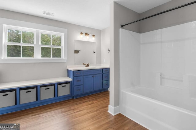 bathroom featuring vanity, hardwood / wood-style flooring, and  shower combination