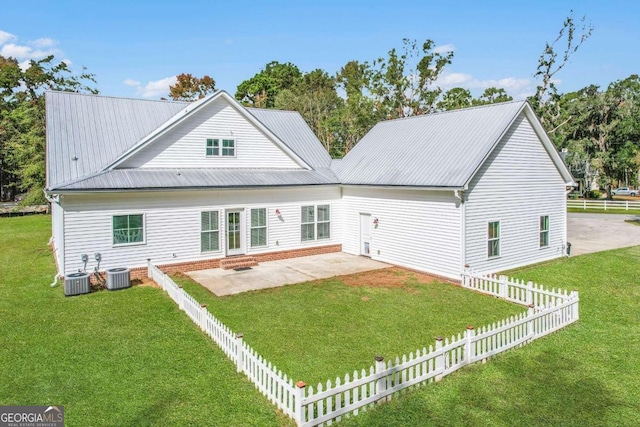 back of house featuring a lawn, central AC, and a patio area