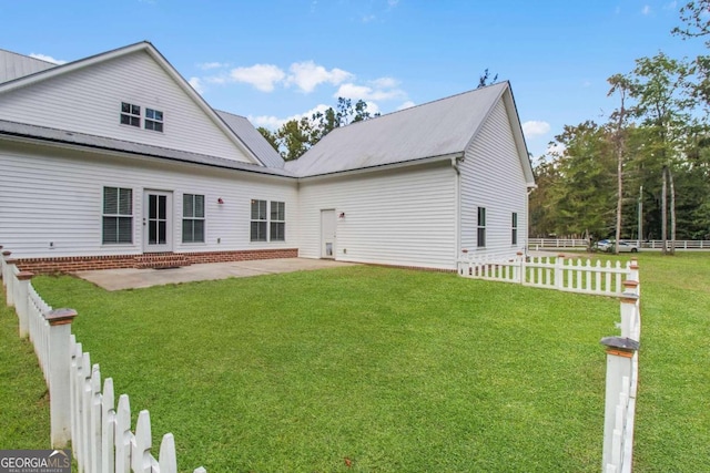 rear view of property featuring a yard and a patio area