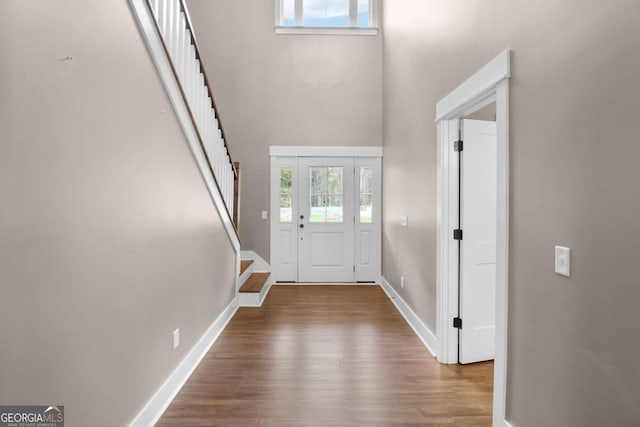 foyer featuring light hardwood / wood-style floors and a towering ceiling