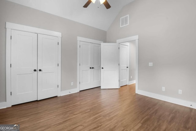 unfurnished bedroom with high vaulted ceiling, wood-type flooring, and ceiling fan