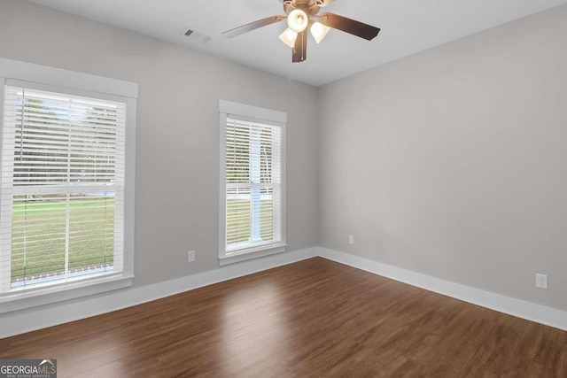 unfurnished room with plenty of natural light, wood-type flooring, and ceiling fan