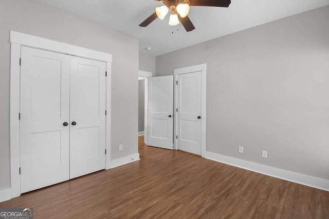 unfurnished bedroom featuring a closet, wood-type flooring, and ceiling fan