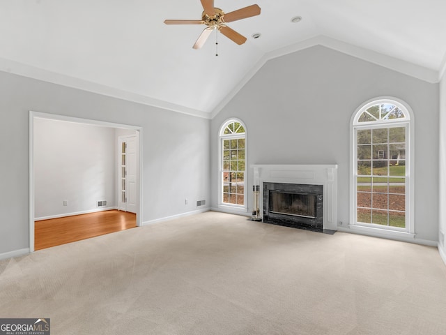 unfurnished living room with a fireplace with flush hearth, lofted ceiling, light carpet, and ceiling fan