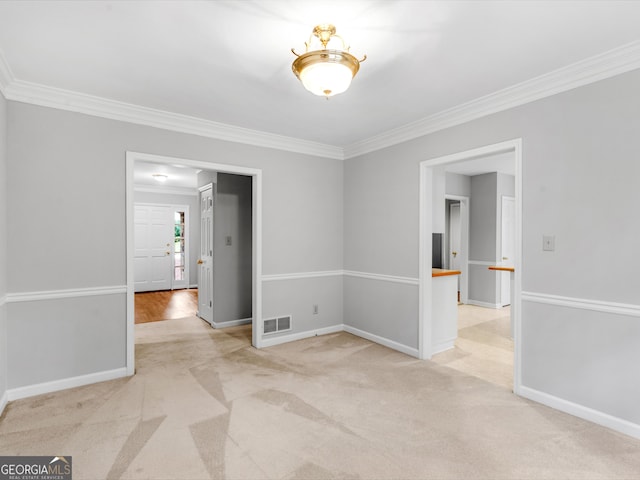 unfurnished room with light carpet, baseboards, visible vents, and crown molding