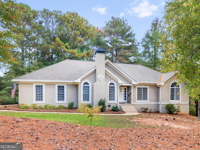 single story home with roof with shingles, a chimney, and stucco siding