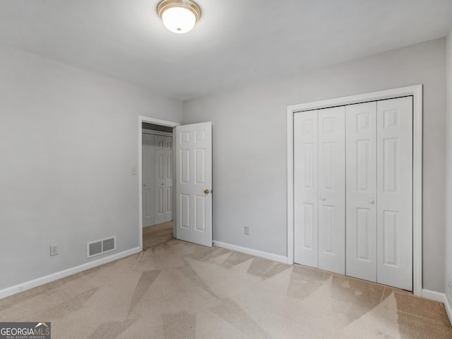 unfurnished bedroom featuring visible vents, light carpet, and baseboards