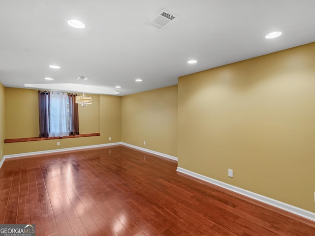 unfurnished room featuring baseboards, visible vents, wood finished floors, and recessed lighting