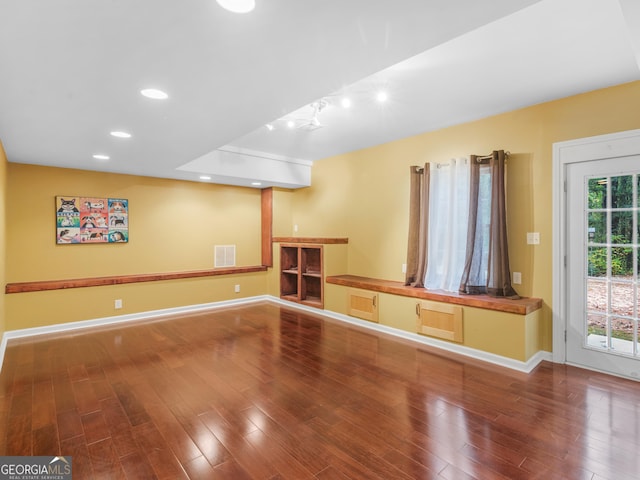 interior space featuring baseboards, visible vents, wood finished floors, and recessed lighting