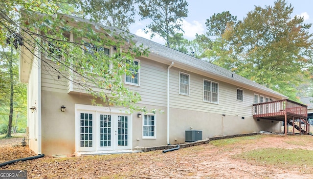 rear view of house featuring french doors, stucco siding, a wooden deck, and central air condition unit