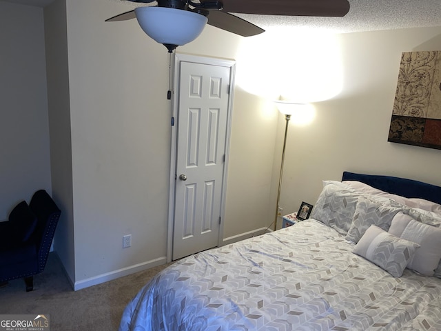 bedroom featuring ceiling fan, carpet floors, and a textured ceiling