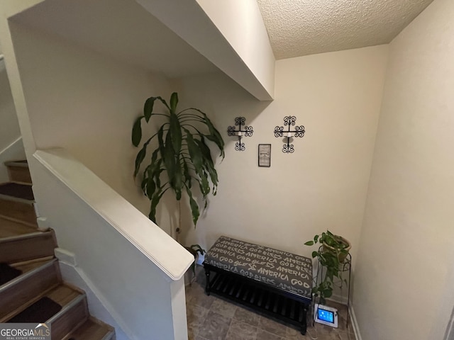 staircase with a textured ceiling