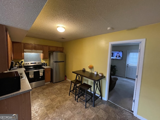 kitchen with a textured ceiling and stainless steel appliances