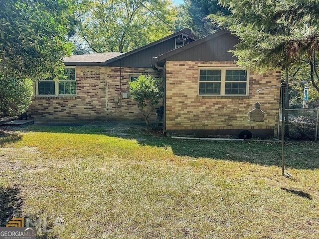 view of side of home with a yard