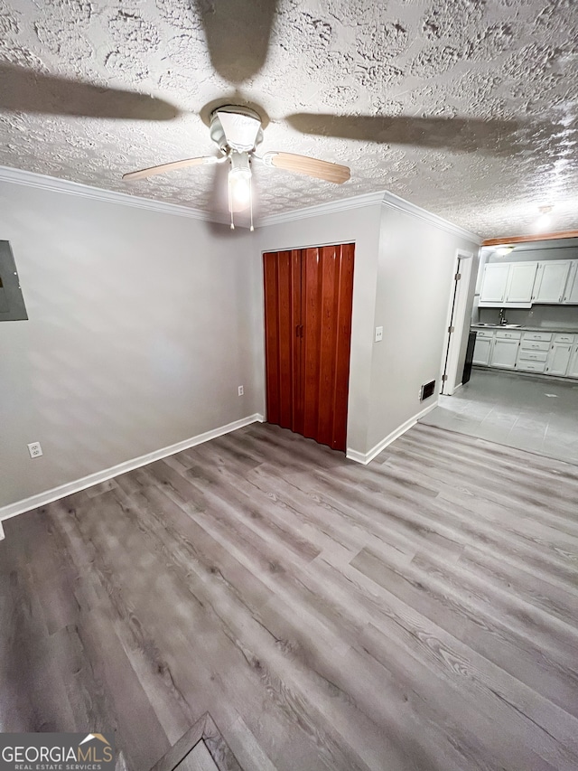 unfurnished bedroom featuring light hardwood / wood-style flooring, a textured ceiling, and ceiling fan