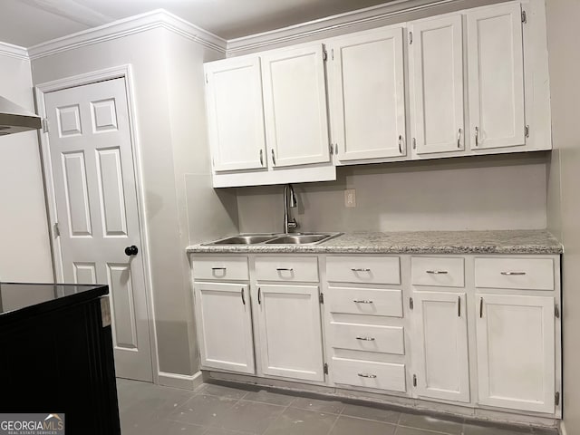 kitchen featuring white cabinetry, sink, dark tile patterned floors, and crown molding